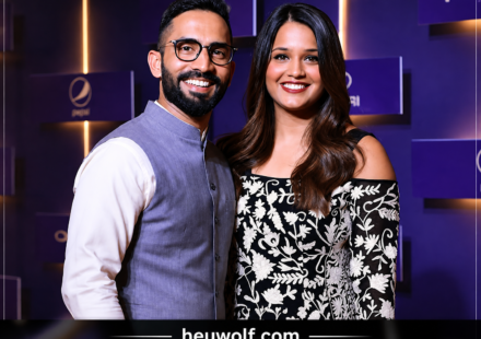 Deepika Pallikal posing with her husband at a public event with a purple backdrop.